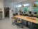 Im Klassenraum der Abschlusstufe steht eine zentrale Tischgruppe, im Hintergrund Arbeitsplätze mit PCs und Lesegeräten.