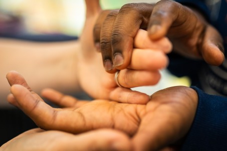 Zwei Hände führen eine andere Hand.