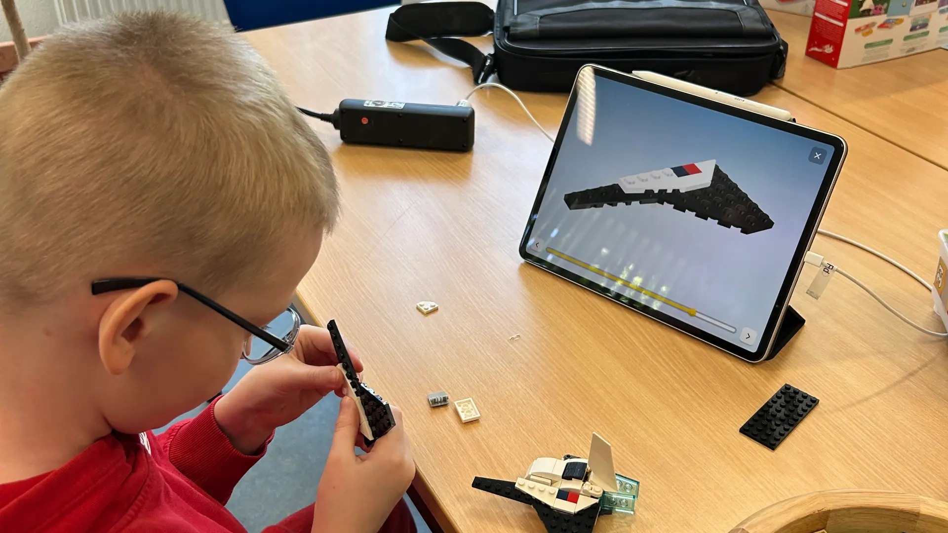 Ein Schüler baut ein Lego-Raumschiff mithilfe der digitalen Bauanleitung