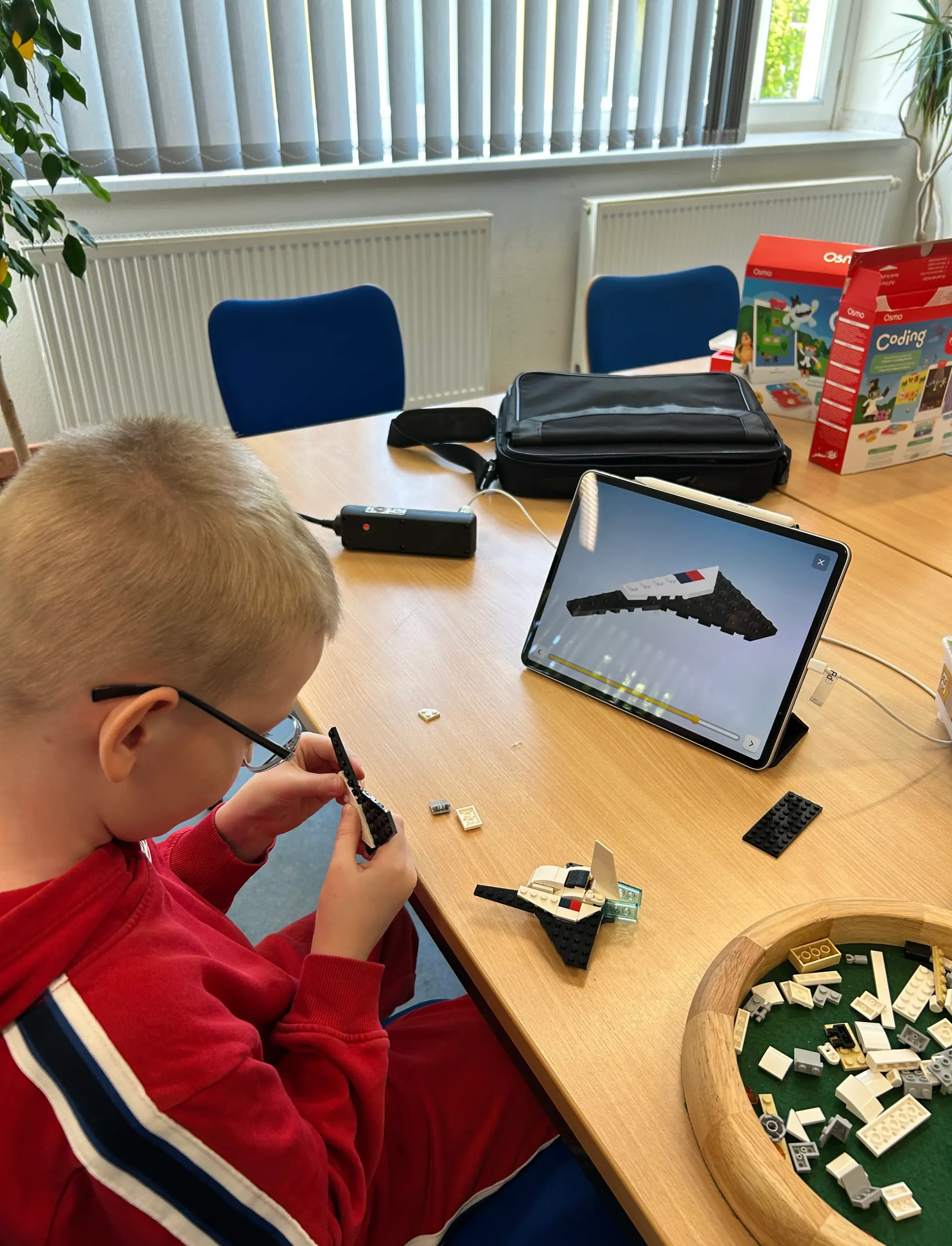 Ein Schüler baut ein Lego-Raumschiff mithilfe der digitalen Bauanleitung