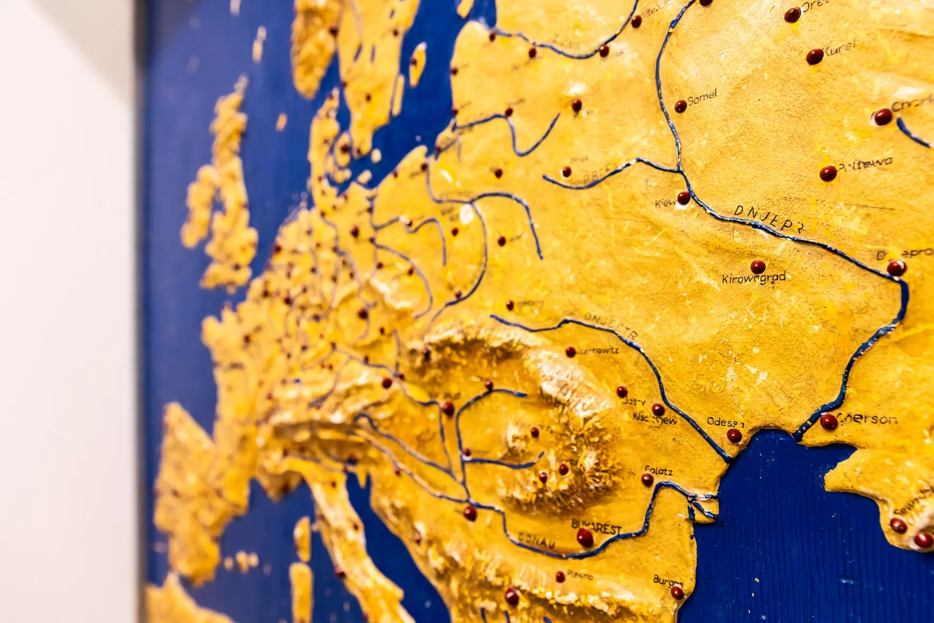 Eine taktile Karte von Europa ganz nah. Die großen Städte sind mit dicken Punkten markiert, die Berge ragen aus dem Bild hervor.
