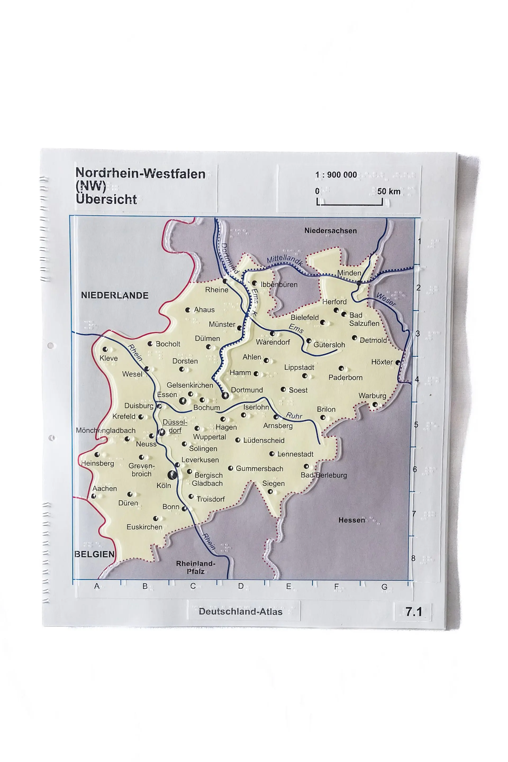 Taktile Karte vom Bundesland Nordrhein-Westphalen. Die Grenzen zu den Nachbarsländern Niederlande und Belgien sowie zu den benachbarten Bundesländern sind dicker markiert. Die Städte sind beschriften und zu jeder einzelnen gibt es einen Kontaktpunkt für den Sprachstift. Die Hauptstadt Düsseldorf ist mit dem größten Punkt gekennzeichnet.