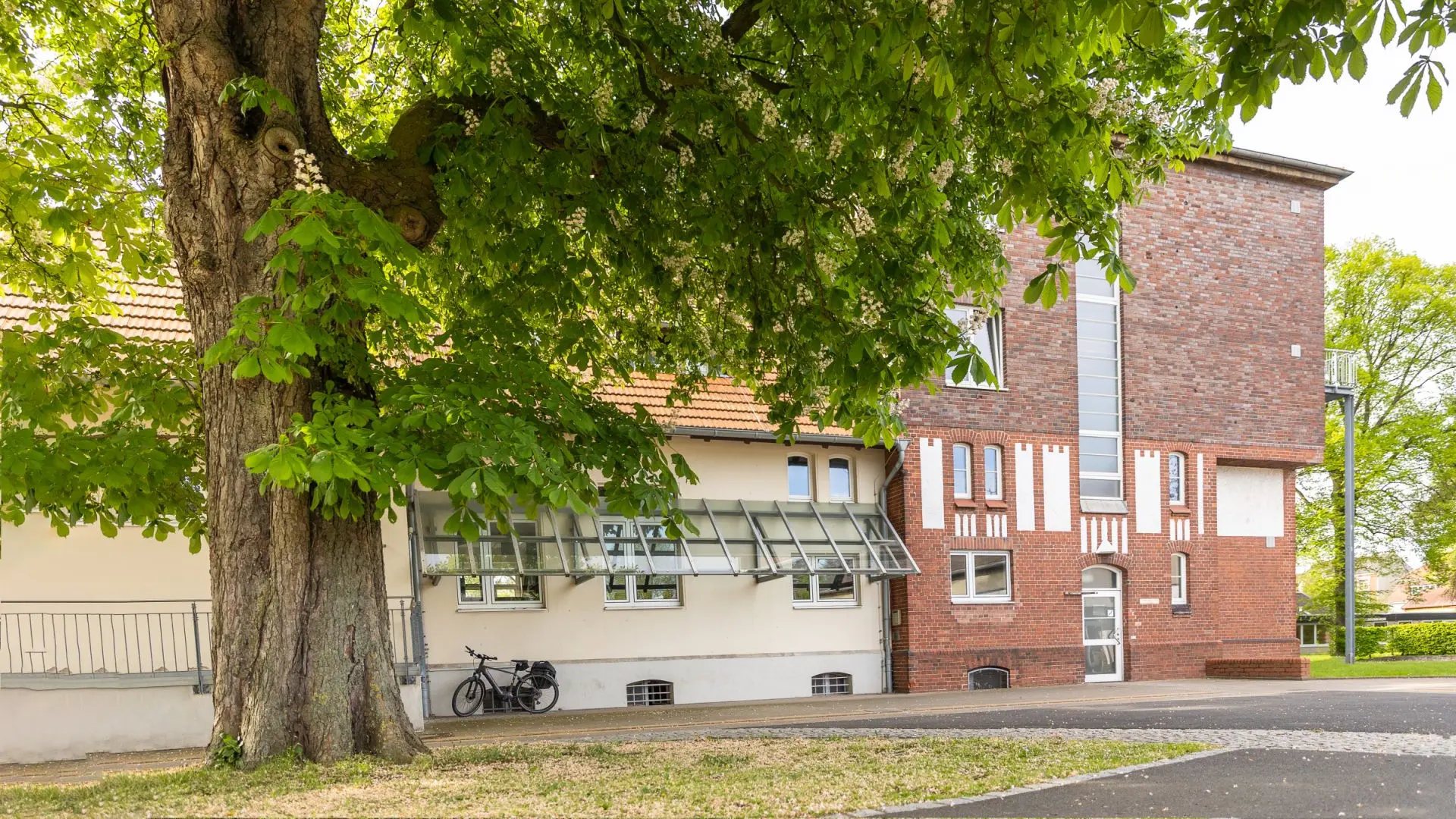Ein Backsteingebäude, wo verschiedene Kurse stattfinden, auf dem Gelände der Förderschule im Sommer