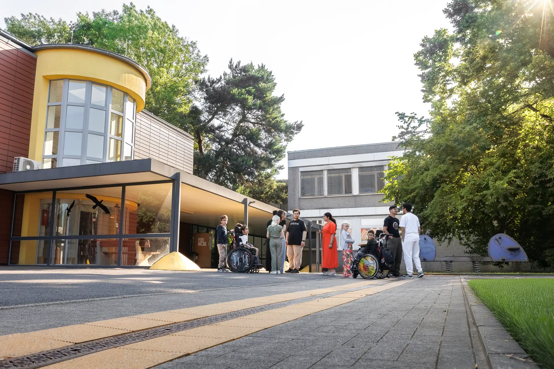 Schüler*innen stehen vor dem Gebäude der Schule